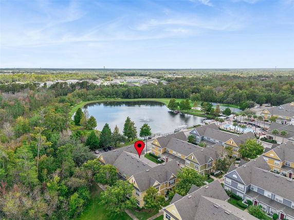 Aerial view of a residential area with a lake and surrounding greenery.