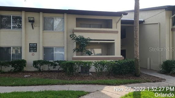 Front view of a two-story residential building with balconies and windows.