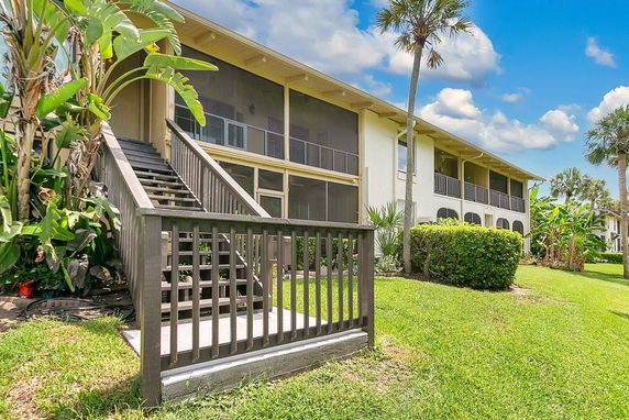 Front view of a two-story building with exterior stairs and screened balconies.