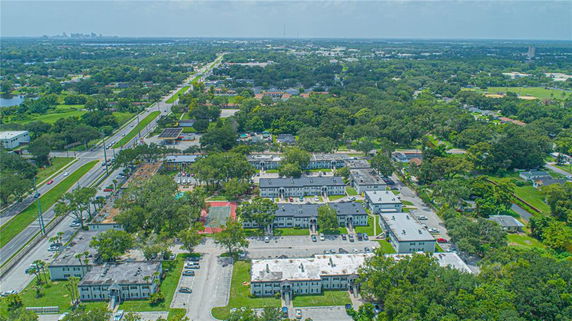 Aerial view of a residential area with multiple buildings and tree-lined streets.