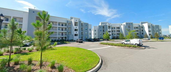 Front view of a large multi-story apartment building with balconies.
