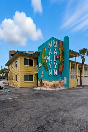 Front view of a two-story building with a colorful mural on the side.