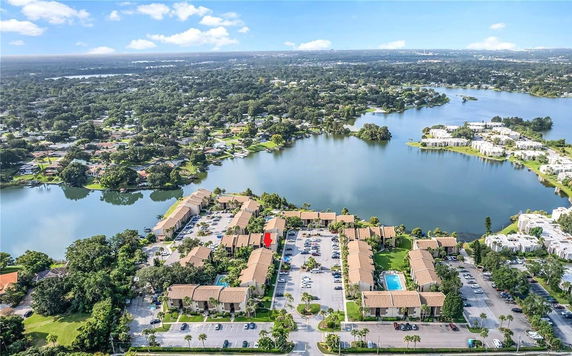 Aerial panoramic view of residential complex with multiple buildings near a lake.