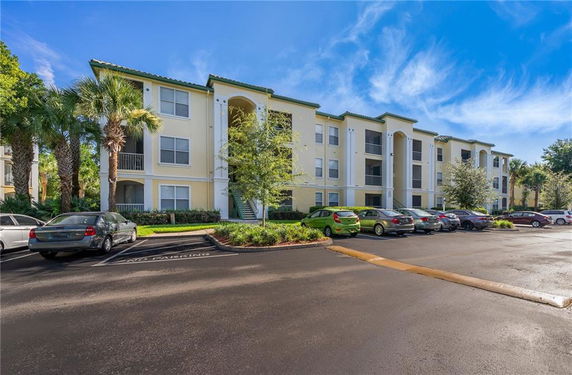 Front view of a three-story apartment building with parking area.