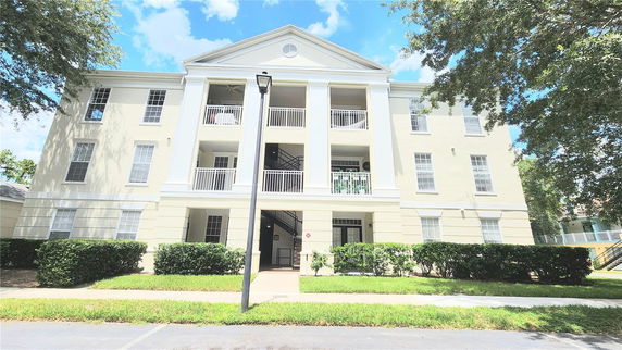 Front view of a multi-story building with columns and balconies.