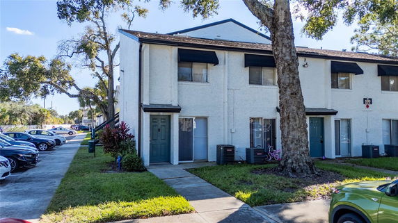 Front view of a two-story townhouse with light exterior and dark trim.