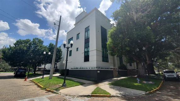 Front view of a modern multi-story building with large windows and a flat roof.