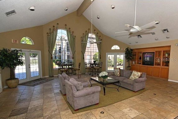Spacious clubhouse room with seating area and large windows.