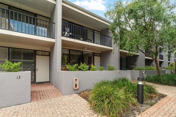 Front view of a modern multi-story residential building with balconies.