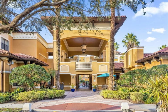 Front view of a large building with an arched entrance and decorative railings.