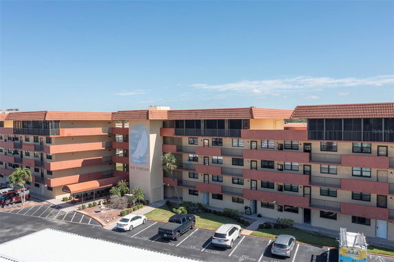 Front view of a multi-story building with parking area.