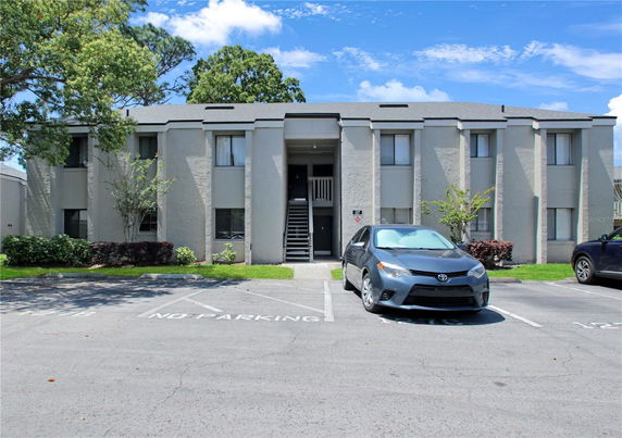 Front view of a two-story residential building with parking area.