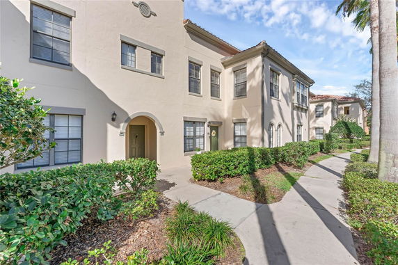Front view of a multi-story residential building with arched entrances and multiple windows.