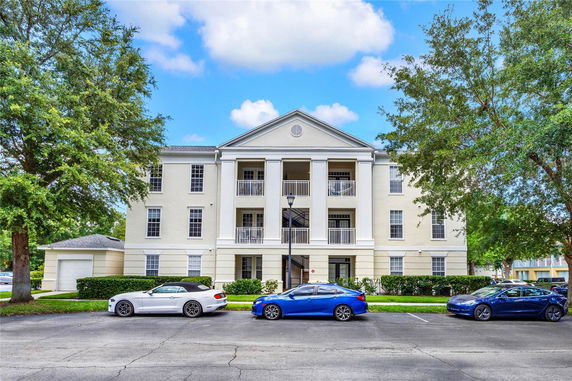 Front view of a three-story building with a symmetrical facade and multiple balconies.