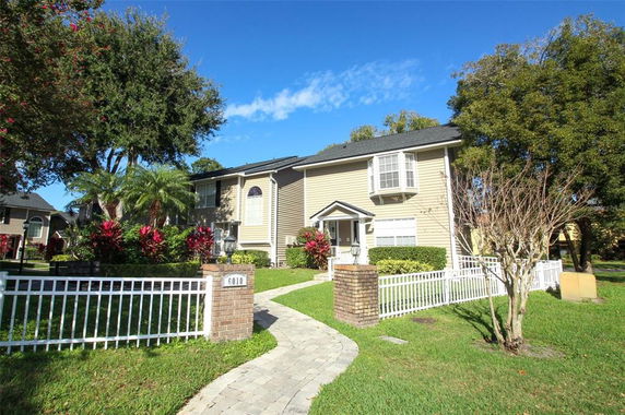 Front view of a two-story house with a beige exterior and white trim.