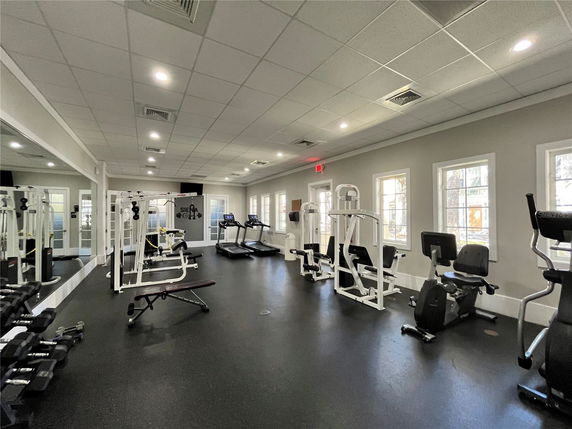 Indoor gym area with exercise equipment and large mirrors.