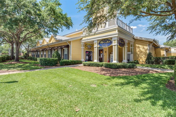 Front view of a yellow building with a porch and multiple gables.