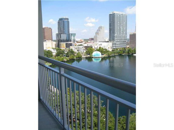 Panoramic view of a city skyline and lake from a balcony.