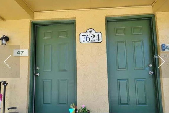 Front view of a building with two green doors and house numbers displayed.