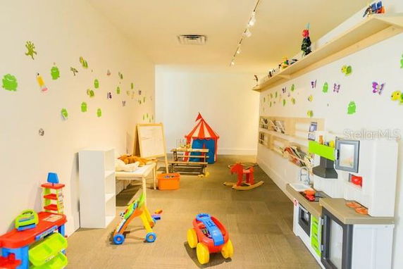 Indoor play area with various toys and wall decorations.