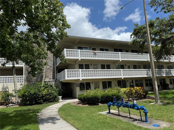 Front view of a three-story residential building with decorative balcony railings.