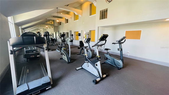 Indoor fitness area with exercise equipment including treadmills and stationary bikes.