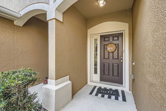 Front entrance of a house with a brown door and a small porch area.