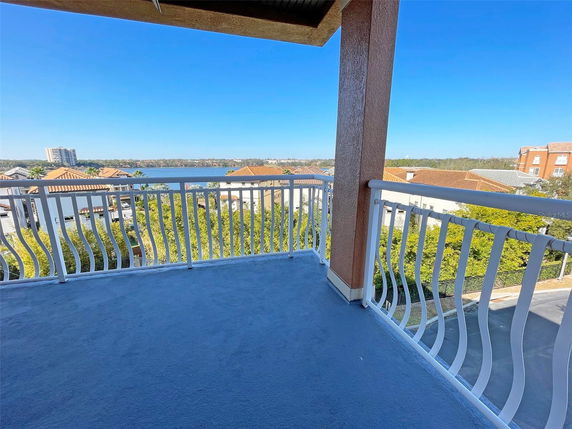 Balcony view overlooking buildings and a water body in the background.
