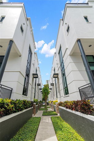 Front view of modern multi-story buildings with white exteriors and tall windows.