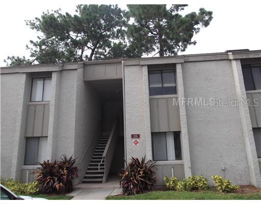 Front view of a two-story apartment building with exterior stairs.