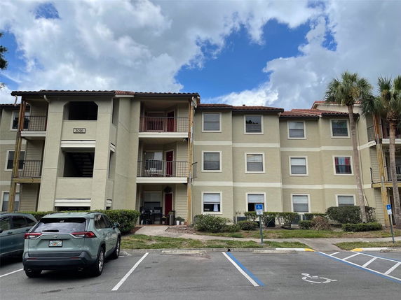Front view of a multi-story apartment building with balconies.