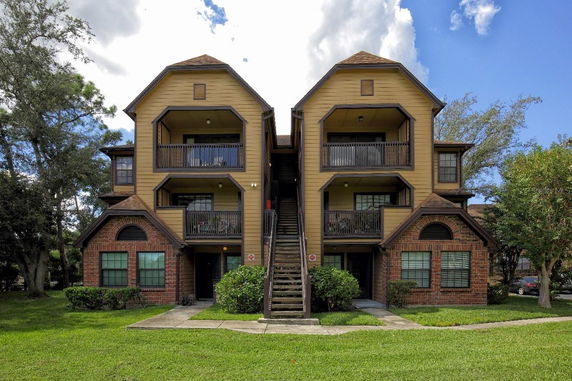 Front view of a multi-story residential building with stair access and balcony.