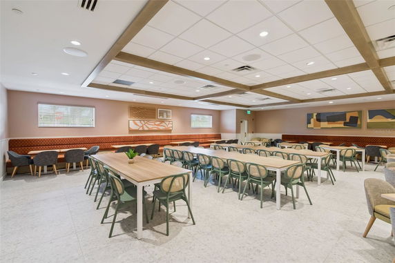 Interior of a clubhouse with tables and chairs arranged for dining or meetings.