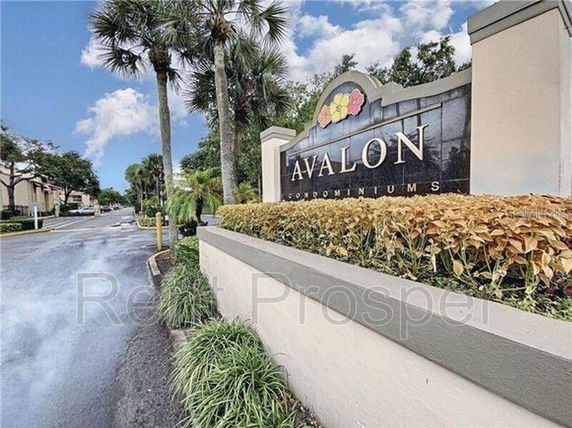Front view of a condominium entrance sign with landscaping.