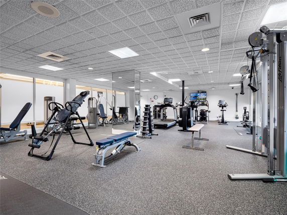 Indoor gym area with exercise equipment and mirrored walls.