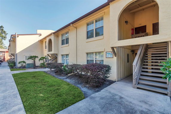 Front view of a two-story apartment building with stairs leading to the upper level.