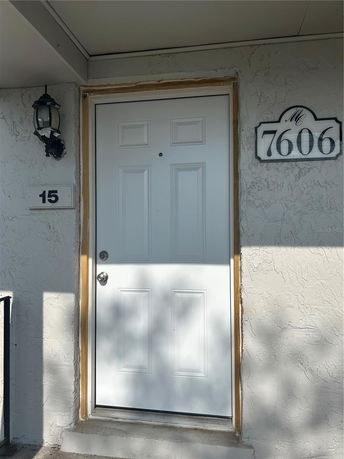Front view of a house entrance with a white door and a house number.