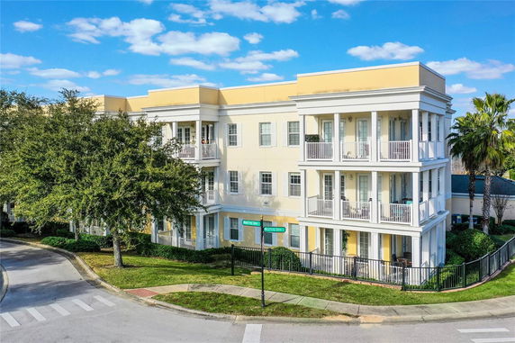 Front view of a three-story residential building with multiple balconies.
