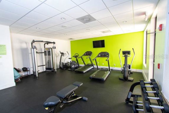Indoor gym area with exercise machines and benches.