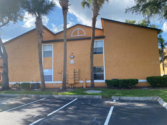 Front view of a building with two floors and parking area in front.