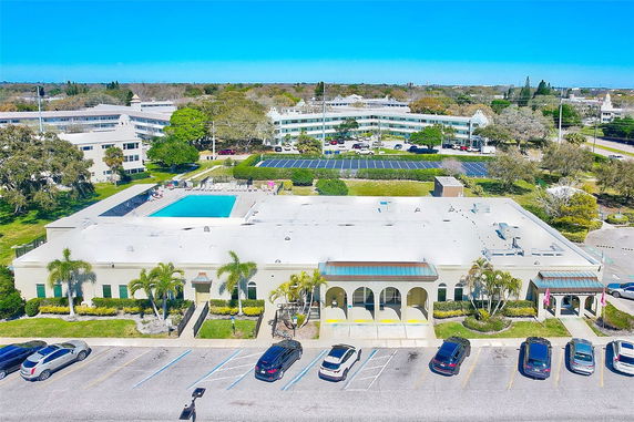 Aerial view of a building complex with a swimming pool and solar panels.