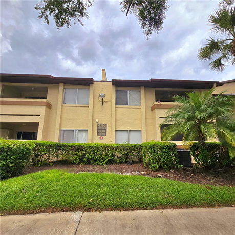 Front view of a two-story apartment building with beige walls and a flat roof.