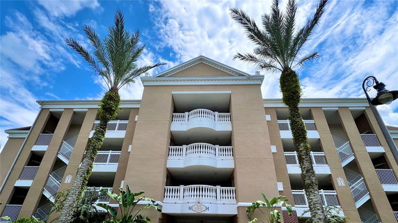 Front view of a multi-story residential building with balconies and tall columns.