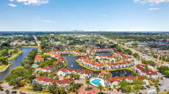 Panoramic view of a residential area with red-roofed houses and surrounding water features.