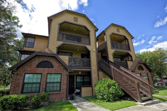 Front view of a multi-story apartment building with exterior stairs and balconies.