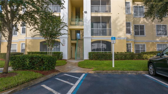 Front view of a multi-story residential building with exterior staircases and balconies.