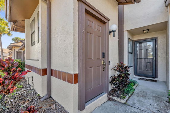 Front view of a house entrance with brown door and decorative tile accent.