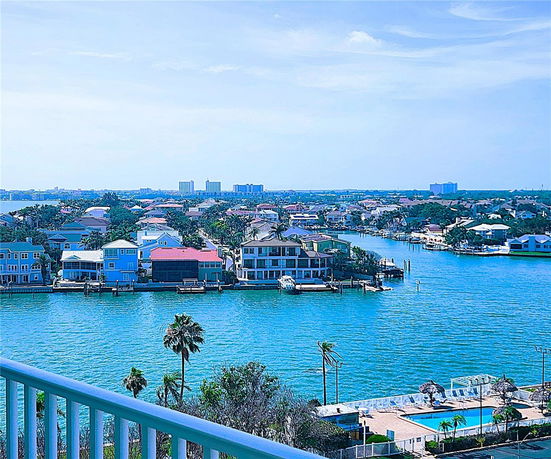 Wide-angle view of a residential area with waterfront houses and a clear blue sky.