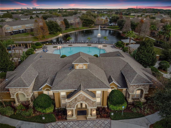 Aerial view of a large building complex with a swimming pool and landscaped surroundings.