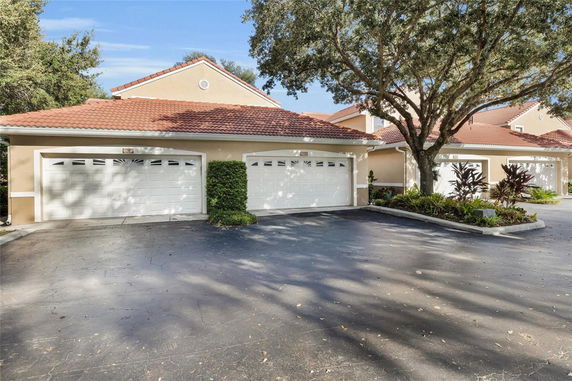Front view of a house with attached double garage and red-tiled roof.